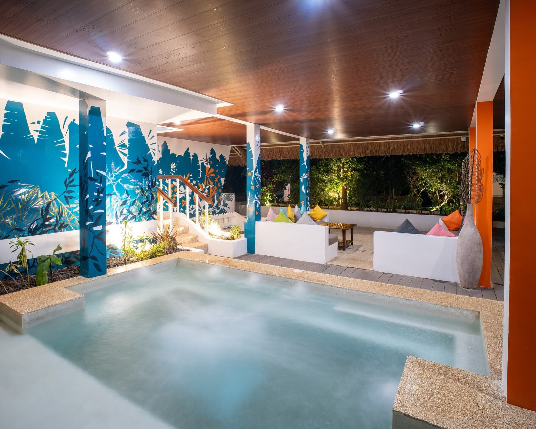 Jacuzzi with lounge seating and tropical mural